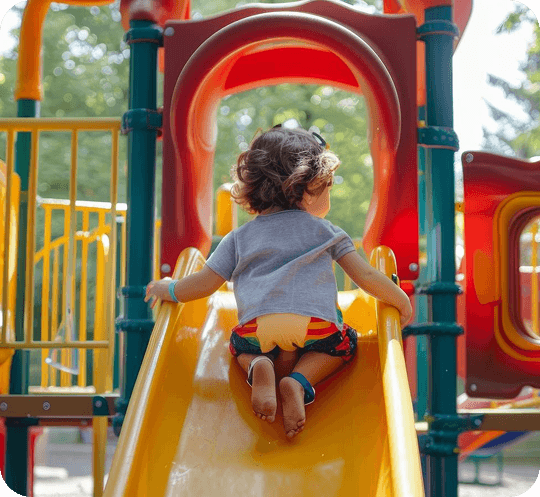 Child climbing up a yellow slide